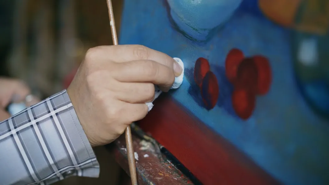 Artist carefully cleaning a painted surface with cloth