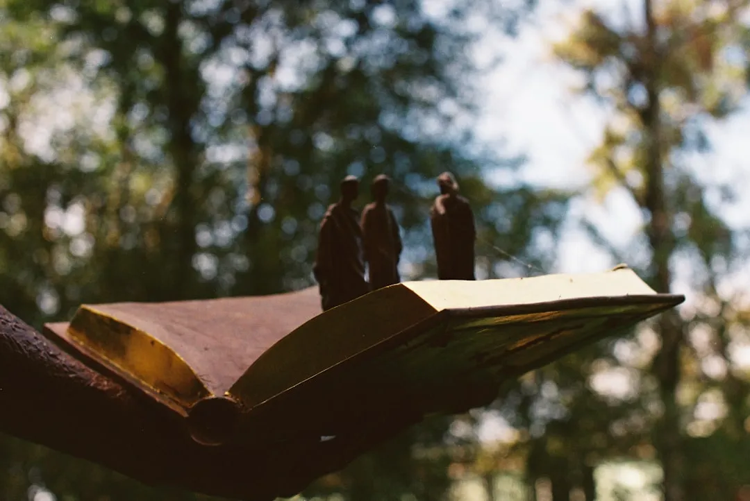 Sculpture of people standing on an open book.