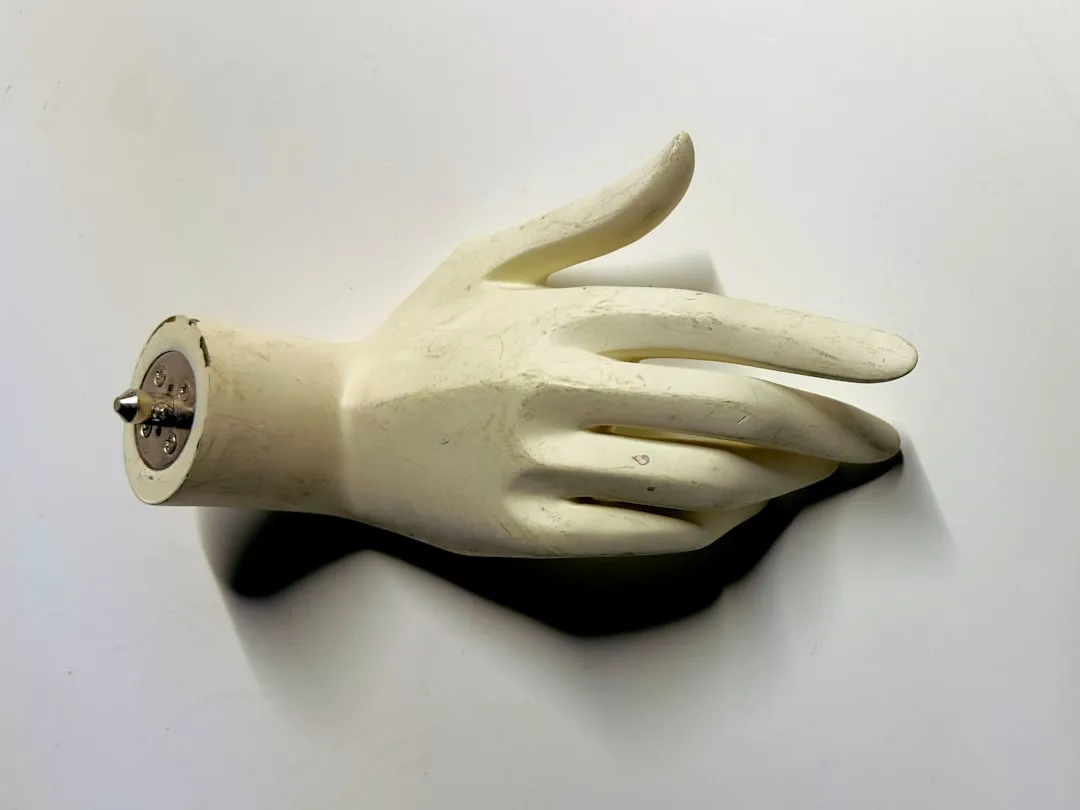 A white glove with a button on it