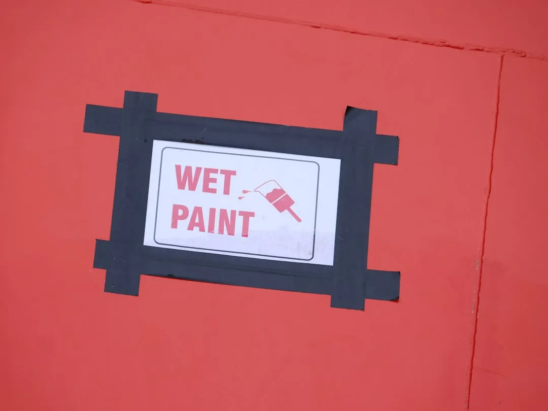 a red wall with a sign that says wet paint