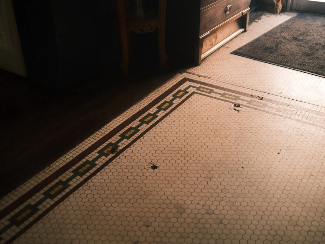 A patterned tile floor in a dim room.